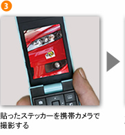 貼ったステッカーを携帯カメラで撮影する